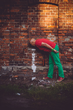 Andrzej Pągowski na tle ceglanej ściany