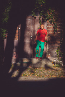 Portret Andrzeja Pągowskiego na tle ceglanej ściany i drzwi - sylwetka